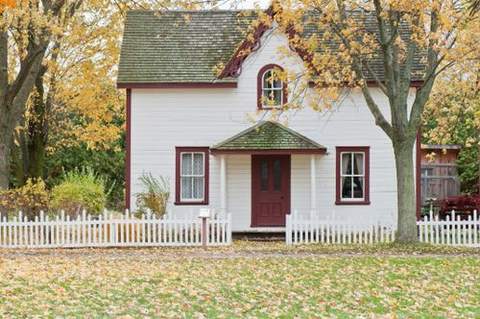 A white cottage-style house with a picket fence