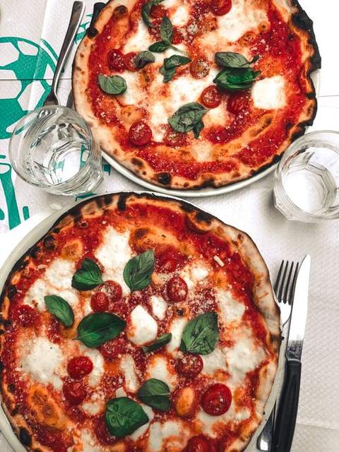 Two fresh pizzas on a table seen from above