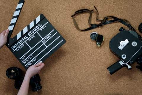 A film clapperboard and camera on a table