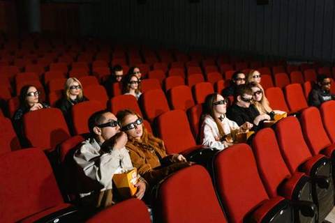 A movie theater audience in red seats