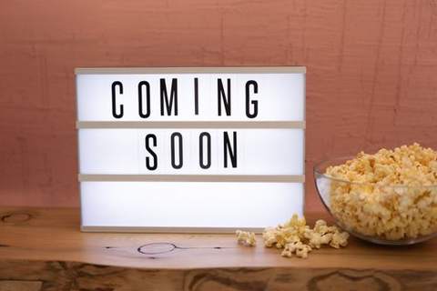 A lightbox sign reading Coming Soon next to a bowl of popcorn